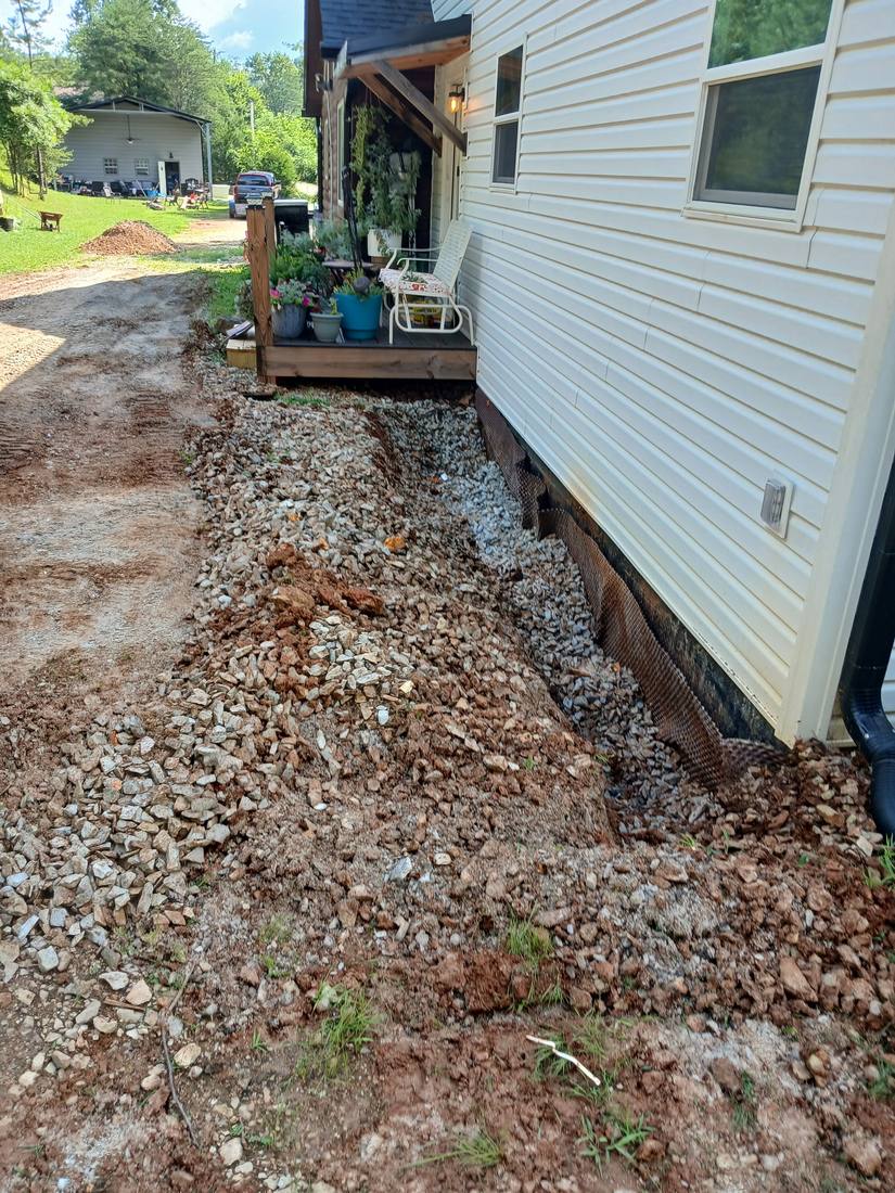 French drain installation with gravel backfill along a house foundation in Campbell County, TN